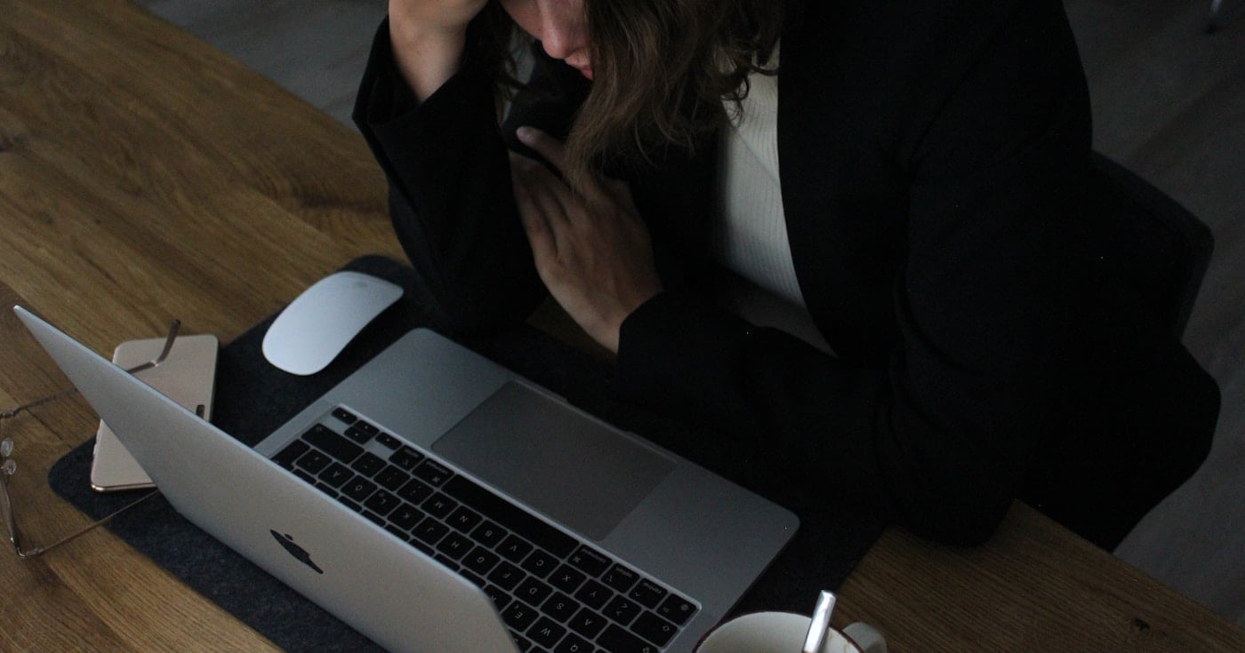 Person at desk showing signs of workplace burnout and stress