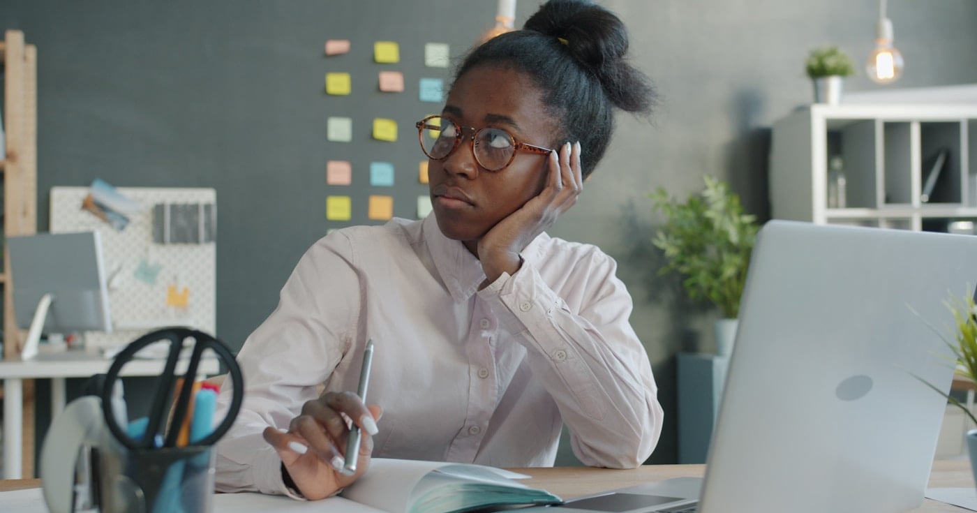 Person thinking at a desk, illustrating the cognitive cost of context switching at work