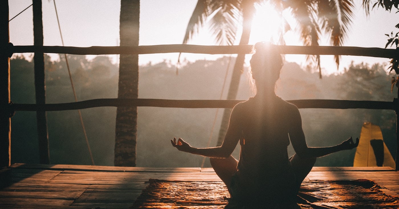 Person practicing morning yoga in a Bali jungle setting, representing monk mode deep focus