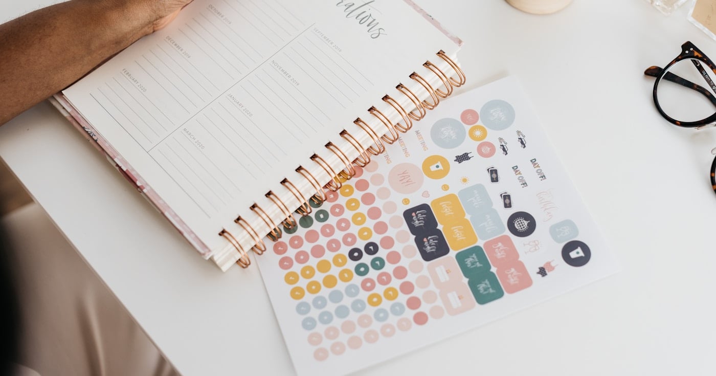 Person writing at desk, planning and managing time