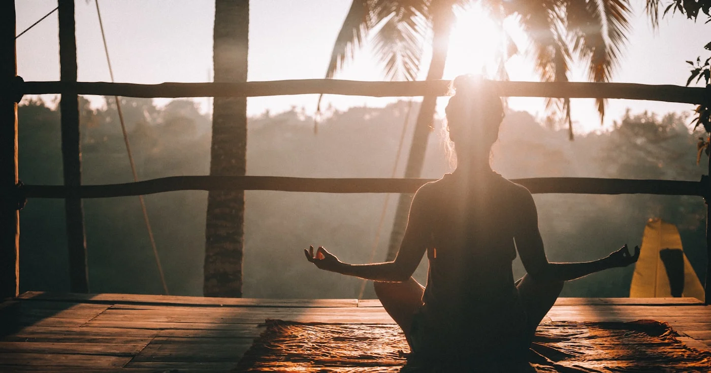 Person practicing morning yoga in a Bali jungle setting, representing monk mode deep focus
